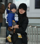 幻灯图：董洁素颜现身机场 怀抱爱子尽显母爱