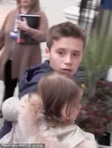 组图：贝克汉姆长子独自抱妹妹看病 保镖紧随