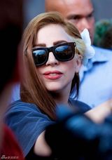 组图：Gaga头戴白花新染棕发亲和亮相