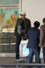 组图：刘烨墨镜遮面机场抽烟 刷微博手机不离手