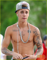 组图：比伯赤膊秀纹身 惬意玩滑板表情囧