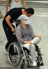 组图：宋丹丹坐轮椅现身机场 跷二郎腿神情悠哉