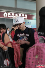 组图：平安现身机场显疲惫 不顾形象狂啃汉堡