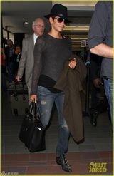 组图：哈莉贝瑞手遮孕肚面带微笑现身机场