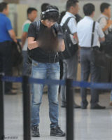 组图：韩寒与王珞丹同机分别现身 低头痴玩手机