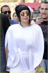 组图：Gaga黑发戴白花扮优雅贵妇 百褶宽袍个性