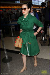 组图：脱衣舞娘蒂塔现身机场 红唇配绿衣潮范足