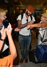 组图：贝克汉姆贝雷帽现身机场 亲民签名魅力足