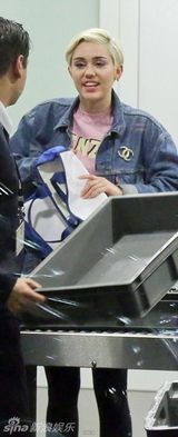 组图：麦莉机场脱衣安检心情不爽做鬼脸