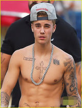 组图：比伯赤膊秀纹身 惬意玩滑板表情囧