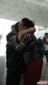 组图：巩俐裤装现身机场 亲民微笑热情拥抱道别