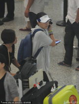 组图：那英穿运动潮装现身机场 握俩手机聊不停