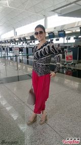 组图：巩俐裤装现身机场 亲民微笑热情拥抱道别