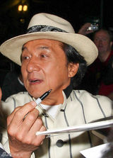 组图：60岁成龙戴礼帽现身英国 见粉丝兴奋挥手