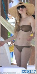 组图：艾薇儿海边度假戏水 腹部平坦破怀孕传闻