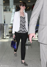 组图：安妮-海瑟薇携夫现身机场黑白搭配显干练