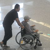 组图：宋丹丹坐轮椅现身机场 跷二郎腿神情悠哉