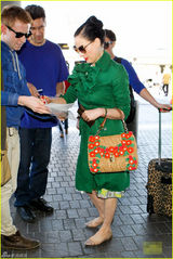 组图：脱衣舞娘蒂塔现身机场 红唇配绿衣潮范足