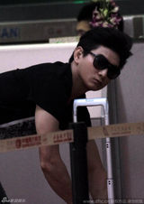 组图：吴奇隆机场收粉丝信件 对镜头黑脸手比停