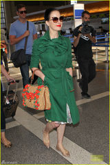 组图：脱衣舞娘蒂塔现身机场 红唇配绿衣潮范足