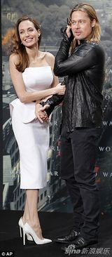 组图：朱莉白裙挽老公娇羞 皮特咬墨镜红毯卖萌