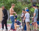 组图：比伯半裸玩滑板秀纹身 裤子滑落露小内