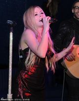 组图:艾薇儿低胸裙亮相庆功派对切蛋糕吐舌搞怪