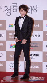 组图：金在中手拿鲜花帅气现身青龙红毯