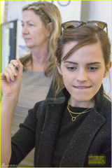 组图：艾玛穿短裙秀美腿 素颜现身机场不停甜笑