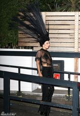 组图：Gaga戴超大孔雀头饰艰难上车俯身露乳