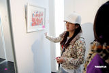 幻灯图：何洁现身自闭儿画展 分身有术赶往录音棚  