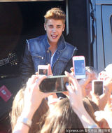 组图：比伯当街献唱谢歌迷 小天王自恋摸发