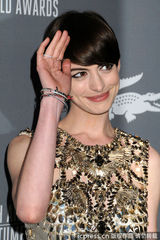 组图：安妮-海瑟薇着金色短裙颁奖  捧奖杯卖萌