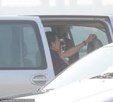 组图：倪萍黑装现身显大姐范 躲车内吸烟损气质