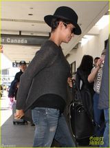 组图：哈莉贝瑞手遮孕肚面带微笑现身机场