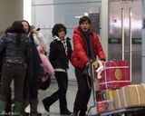 幻灯图：刘晓庆易钢演出归来 阿峰机场笑脸相迎