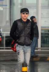 组图：黄渤携美女助理回京 机场被路人索要签名