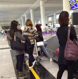 组图：杨幂口罩遮面打扮萌态 坐行李车小心护胎