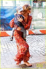 组图：米兰达深V长裙美艳 小宝贝幸福躺妈肩头