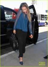 组图：阿尔芭憔悴亮相机场 肩夹手机忙通话