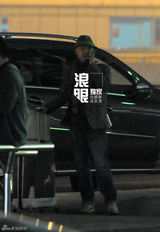 组图：徐峥戴绿边帽独自回京 把玩手机目光呆滞