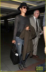 组图：哈莉贝瑞手遮孕肚面带微笑现身机场