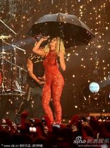 组图：Rita Ora撑黑伞演出 红色蕾丝连身裤秀身段