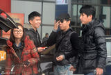 组图：黄渤携美女助理回京 机场被路人索要签名