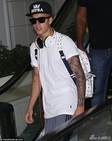 组图：比伯白衫现身机场 抱BB吻粉丝表现亲切