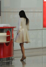 组图：伊能静寒冬穿短裙回京 坐桌子上等行李