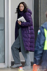 组图：劳伦斯披紫袄现身片场 素颜显知性气质