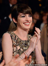 组图：安妮-海瑟薇着金色短裙颁奖  捧奖杯卖萌