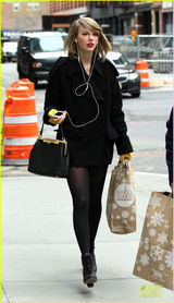 组图：斯威夫特黑丝秀美腿 妆容精致遭路人忽略