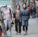 组图：刘亦菲街头拍戏 羽绒服配裙子显另类